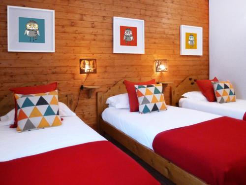 two twin beds in a room with wooden walls at Résidence Les Fermes Du Planet - Chalets pour 12 Personnes 74 in Valloire