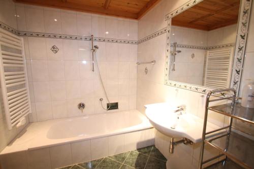 a white bathroom with a tub and a sink at Ferienwohnung Königsleiten 37 - Top 1 in Königsleiten