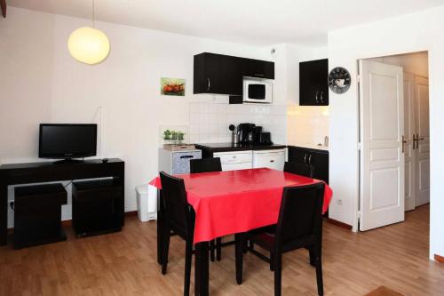 une cuisine avec une table rouge et des chaises noires dans l'établissement Residence La Combe D Or - Appartement en résidence de standing MAE-6254, aux Orres