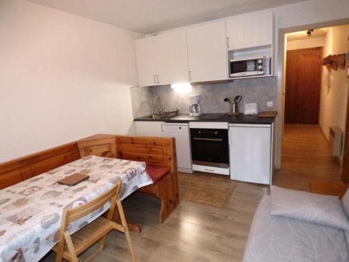 une cuisine avec une table et une petite cuisine avec une table et des chaises dans l'établissement Résidence Eden Val - Studio cabine 3 personnes 2 exposé Sud MAE-8154, à Valloire