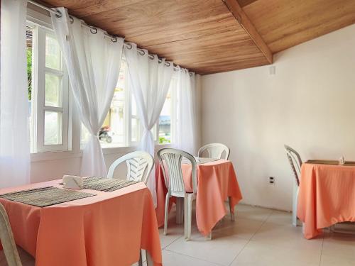 uma sala de jantar com mesas e cadeiras e uma janela em Pousada Hospedagem Caribe em Arraial do Cabo