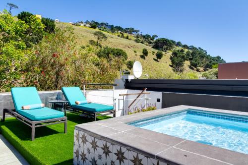 un patio con 2 sillas y una piscina en Cape Finest Guest House located in De Waterkant, en Ciudad del Cabo