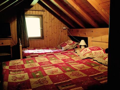 a bedroom with a bed with a red and white quilt at Chalet Les Lupins - 4 Pièces pour 8 Personnes 14 in Valloire