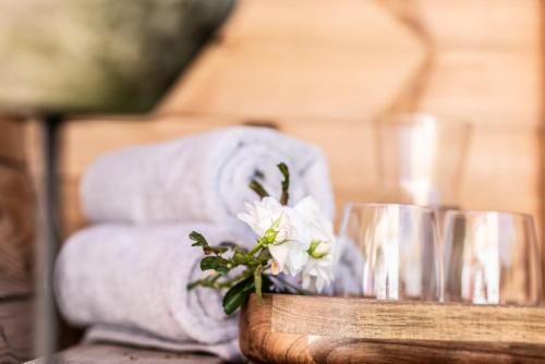 ein Tisch mit Handtüchern und ein Blumenstrauß in der Unterkunft Exklusives Design-Apartment & Sauna in Warngau