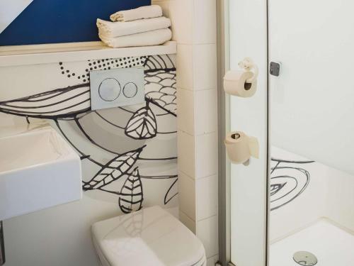 a bathroom with a toilet and a shower at ibis budget Dijon Saint Apollinaire in Saint-Apollinaire