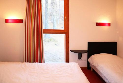 a room with two beds and a window at Chalet La Combe D Or - Chalets pour 6 Personnes 094 in Le Mélézet