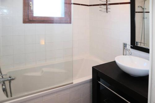 a white bathroom with a sink and a tub and a sink at Chalet La Combe D Or - Chalets pour 6 Personnes 094 in Le Mélézet