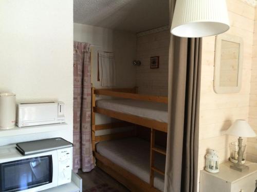 a small room with bunk beds and a microwave at Résidence Betelgeuse - Studio pour 3 Personnes 64 in Valloire