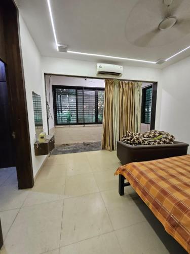 a bedroom with a bed and a large window at Patil's Greenwoods FarmHouse in Navi Mumbai