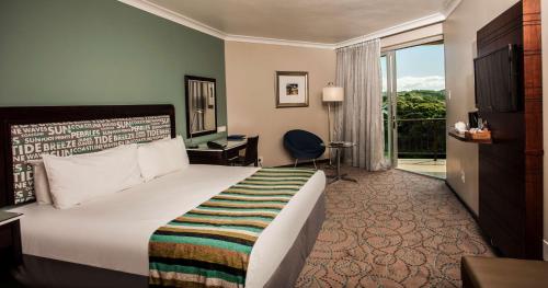 a hotel room with a bed and a desk and a window at Garden Court East London in East London