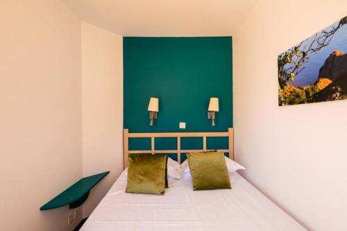 - une chambre dotée d'un lit avec un mur vert dans l'établissement Résidence le Village de Cap Esterel - maeva Home - Appartement 2 pieces 5 personnes Selection MAE-3658, à Saint-Raphaël