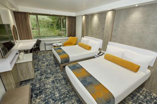 Pokój hotelowy z 2 łóżkami i biurkiem w obiekcie Garden Court Mthatha w mieście Mthatha
