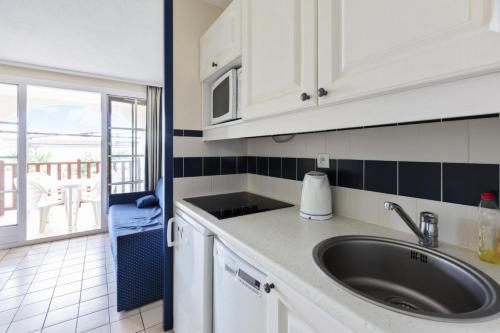 - une cuisine avec évier et vue sur l'océan dans l'établissement Résidence Port Bourgenay - maeva Home - Appartement 2 pièces 5 personnes Selection MAE-3681, à Talmont-Saint-Hilaire