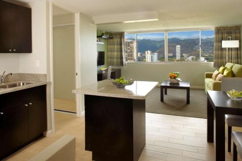 a kitchen and living room with a view of a city at Skyline Island Colony Hotel in Honolulu