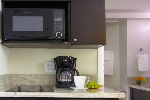 a kitchen with a coffee maker and a microwave at Skyline Island Colony Hotel in Honolulu