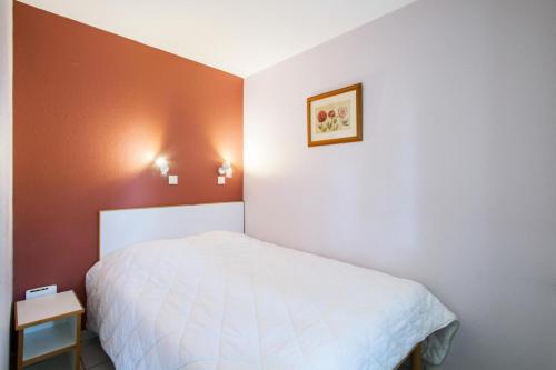 - une petite chambre avec un lit blanc et des murs orange dans l'établissement Village Moliets - maeva Home - 2 pièces 5 pers Sélection MAE-4493, à Moliets-et-Maa