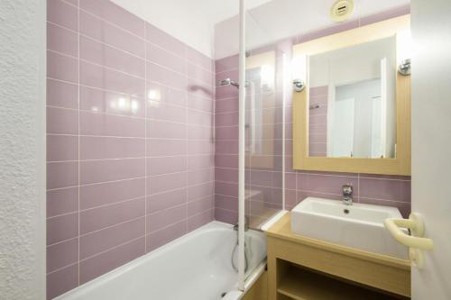 une salle de bain avec une baignoire, un lavabo et un miroir dans l'établissement Village Moliets - maeva Home - 2 pièces 5 pers Sélection MAE-4493, à Moliets-et-Maa