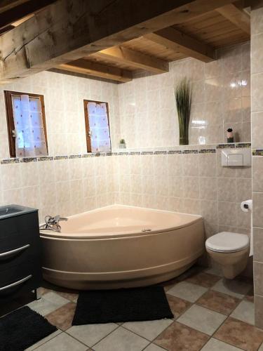 a bathroom with a large tub and a toilet at Chalet Colenfrey - Chalets pour 10 Personnes 14 in Valloire