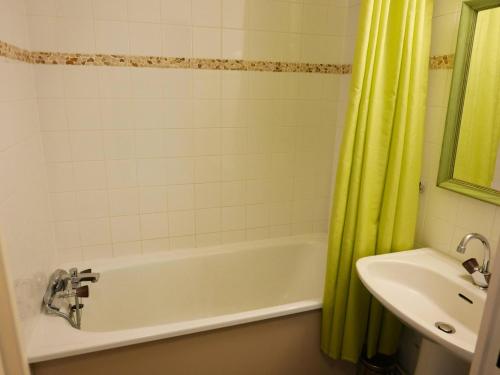 y baño con bañera blanca y lavamanos. en Résidence Plan Soleil - Studio pour 4 Personnes 64, en Valloire
