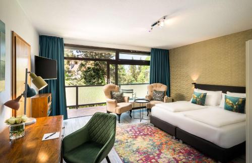 アウクスブルクにあるArthotel ANA Goldのベッドとデスクが備わるホテルルームです。