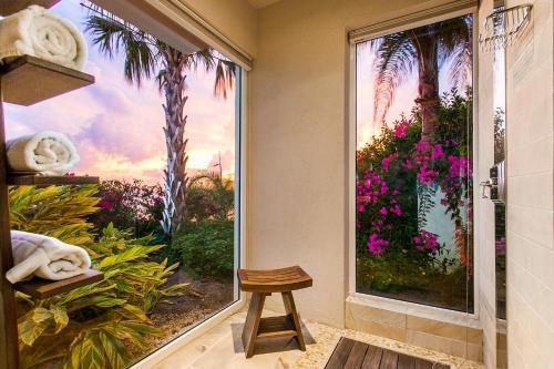 a bathroom with a window with a view of a garden at CeBlue Villas in The Valley