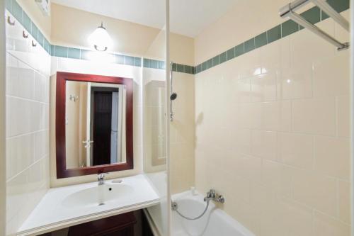a bathroom with a sink and a mirror and a tub at Résidence Le Domaine de Gascogne - maeva Home - Appartement 2 pièces 5 personnes Confort MAE-4457 in Biscarrosse