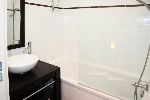 ein weißes Badezimmer mit einem Waschbecken und einer Badewanne in der Unterkunft Chalet La Combe D Or - Chalets pour 6 Personnes 964 in Le Mélézet