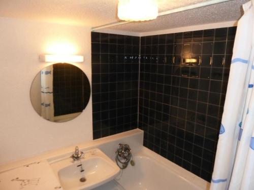 une salle de bain avec un lavabo, une baignoire et un miroir dans l'établissement Résidence Les Cassettes - Studio 2 personnes 2 exposé Sud MAE-8394, à Valloire