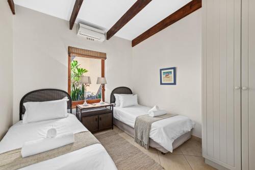 1 dormitorio con 2 camas y ventana en San Lameer Villa 2608 - 4 Bedroom Classic - 8 pax - San Lameer Rental Agency en Southbroom