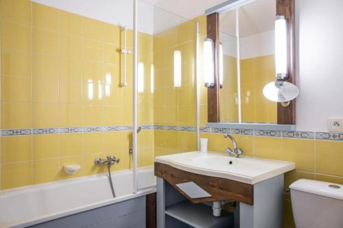 une salle de bain avec un lavabo, une baignoire et un miroir dans l'établissement Les Maisons de Port Bourgenay - maeva Home - Maison 3 pièces 8 pers Sélection MAE-5843, à Talmont-Saint-Hilaire
