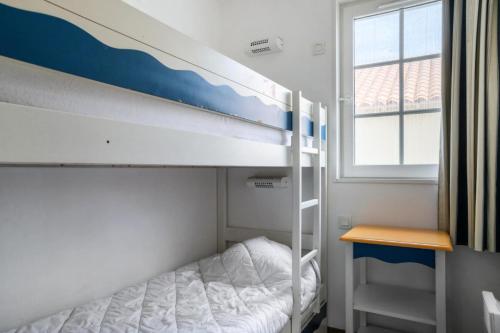 une chambre avec un lit superposé et un bureau dans l'établissement Les Maisons de Port Bourgenay - maeva Home - Maison 3 pièces 8 pers Sélection MAE-5843, à Talmont-Saint-Hilaire