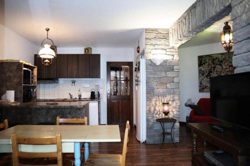 une cuisine et une salle à manger avec une table et une salle à manger gmaxwell gmaxwell dans l'établissement Résidence Les Carlines - 607 LES CARLINES 1650 MAE-1011, aux Orres