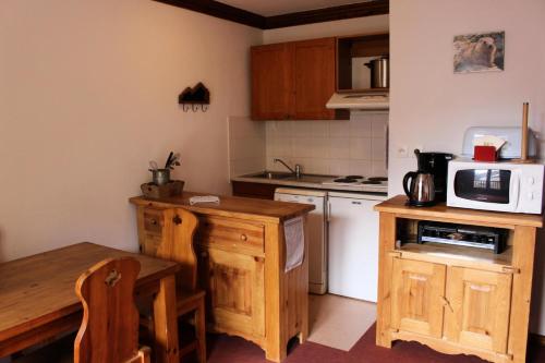 a small kitchen with a table and a microwave at Résidence Les Valmonts - 2 Pièces pour 4 Personnes 04 in Valloire
