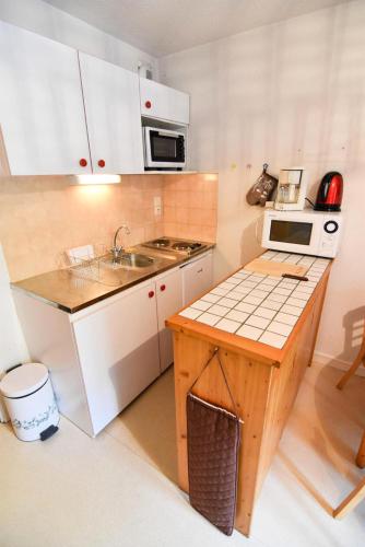 une petite cuisine avec un évier et un micro-ondes dans l'établissement Residence Le Thymel - Studio cabine 3 personnes 2 exposé Est MAE-8514, à Valloire