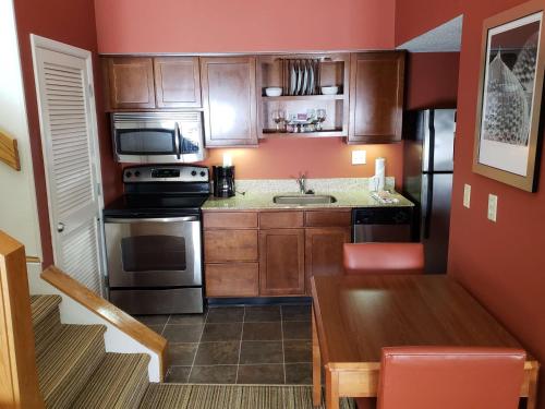 a small kitchen with a sink and a stove at Tysons Corner Suites, A Baymont by Wyndham in Vienna