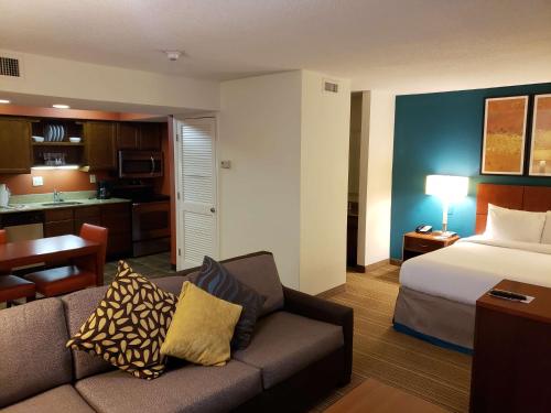 a hotel room with a couch and a bed and a kitchen at Tysons Corner Suites, A Baymont by Wyndham in Vienna
