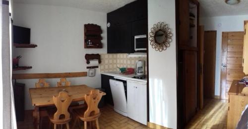 a kitchen with a wooden table and a table and chairs at Résidence Pre Malin - 2 Pièces pour 4 Personnes 84 in Valloire