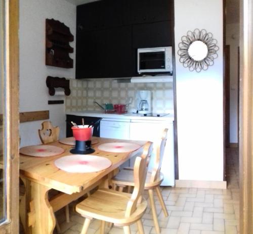 a kitchen with a wooden table and chairs in a kitchen at Résidence Pre Malin - 2 Pièces pour 4 Personnes 84 in Valloire