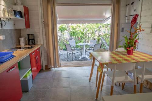 een keuken en eetkamer met een tafel en stoelen bij Chalet de 2 chambres a Vieux Habitants a 300 m de la plage avec terrasse et wifi in Vieux-Habitants
