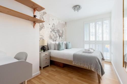 a white bedroom with a bed and a window at The East Dulwich Collection in London