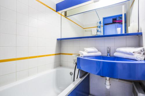 La salle de bains est pourvue d'un lavabo bleu et d'une baignoire. dans l'établissement Résidence le Village de Cap Esterel - maeva Home - Studio 5 personnes - Budget MAE-5883, à Saint-Raphaël