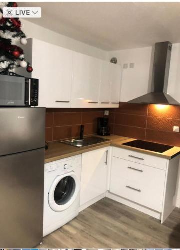 une cuisine avec des armoires blanches et un arbre de Noël dans l'établissement Résidence Antigua - T2 4 couchages LE BARCARES - CLIMATISATION en option MAE-7984, au Barcarès