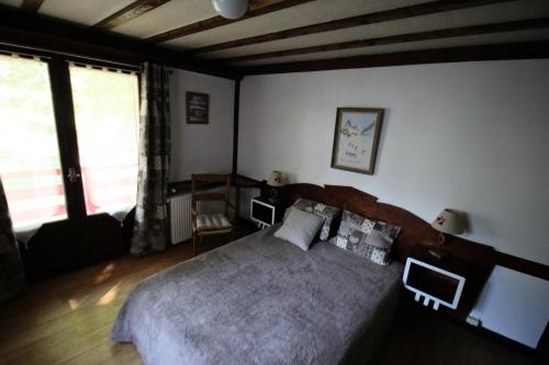 une chambre avec un grand lit et une grande fenêtre dans l'établissement Chalet Ickory - 3 pièces 6 personnes 3 exposé Sud MAE-8564, à Valloire