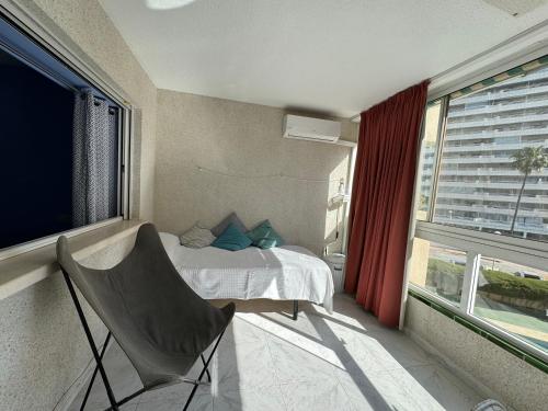 een slaapkamer met een bed, een stoel en een raam bij Apolo XI Calpe vistas al mar in Calpe