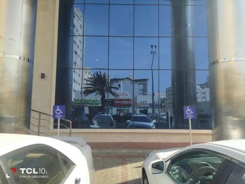 dos autos blancos estacionados frente a un edificio en فندق اوبن هوتيل مكه المكرمه en La Meca