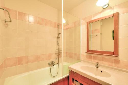une salle de bain avec une baignoire, un lavabo et un miroir dans l'établissement La résidence du Lac - maeva Home - Maison 3 pièces 6 personnes Prestige MAE-6846, à Monflanquin