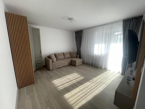 a living room with a couch and a window at Luxury Apartment in Piteşti