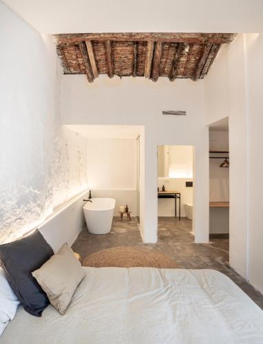 a white bedroom with a bed and a bath tub at Casa cristo 37 navarrés in Navarrés