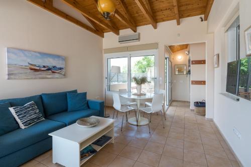 a living room with a blue couch and a table at Andreas House in Lixouri