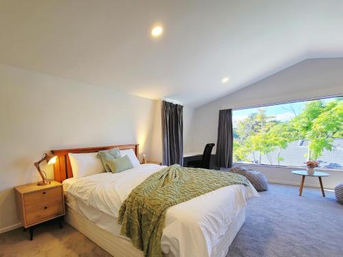 a bedroom with a bed and a large window at Bay Villa with 5 Bedrooms and 5 Bathrooms in Whangaparaoa